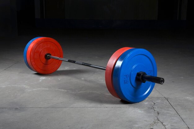 Barbell bar and barbell plate on black background.