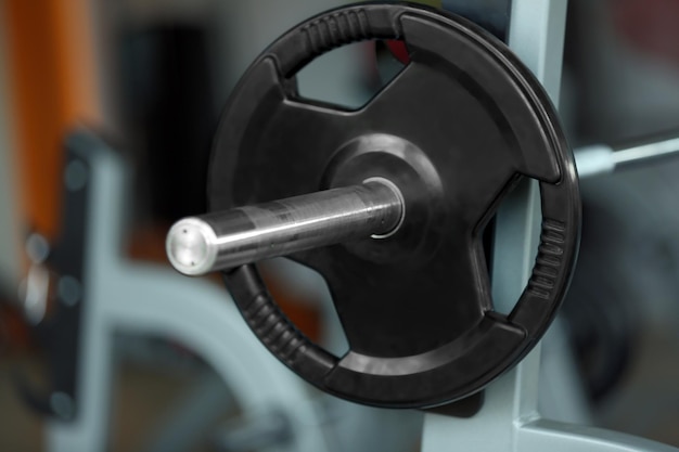 Barbell on rack in gym close up