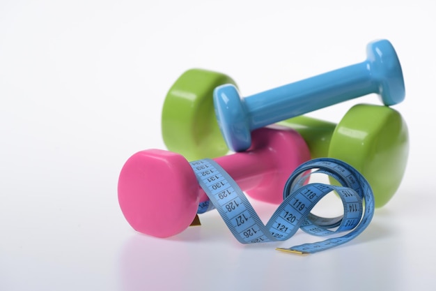 Barbells next to cyan measure tape close up Sport concept