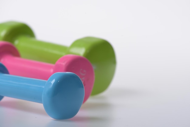 Barbells in pink green and blue colors close up