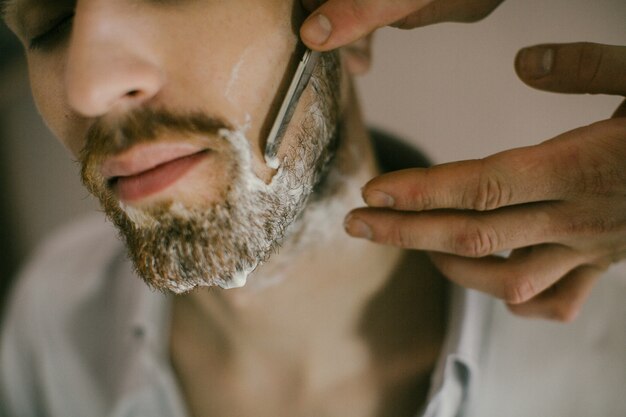 Barber applies shaving cream to the face