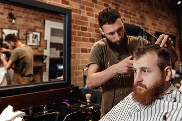 Barber and bearded man in barber shop