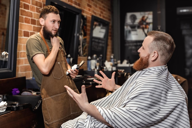 Barber and bearded man in barber shop