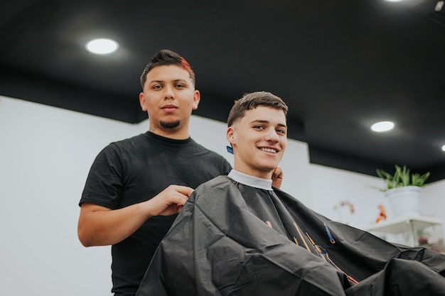 Barber and customer smiling to the camera
