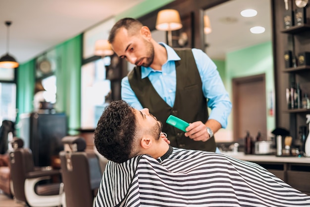 Barber cutting clients hair in salon