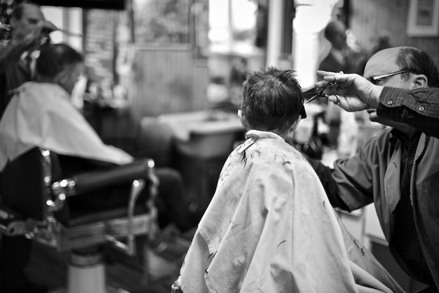 Foto barbiere che taglia i capelli di un ragazzo