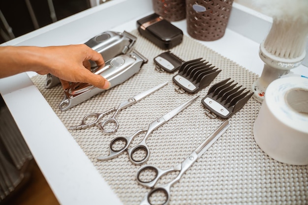 Barber hand picking an shaver haircut instrument from the table