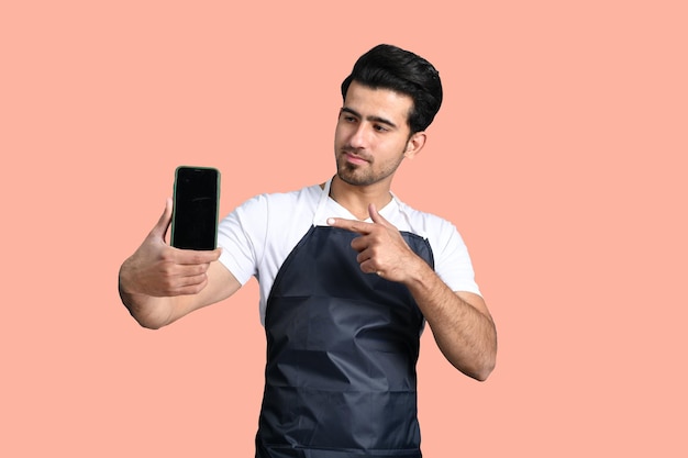 barber holding phone and poinitng it indian pakistani model