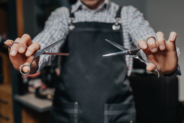 Photo barber holding scissors with apron on