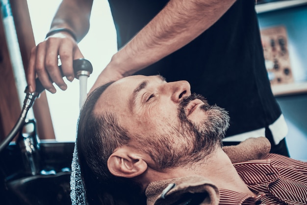 Barber Is Washing Customers Black Hair From Tap.