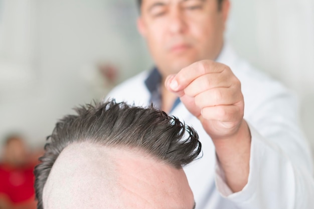 Barber makes a mohawk hairstyle at the adult man with beard