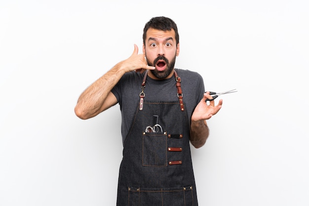 Barber man in an apron making phone gesture and doubting