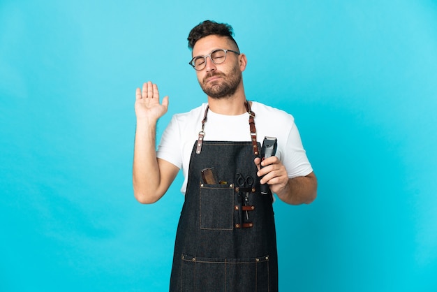 Barber man in an apron making stop gesture and disappointed