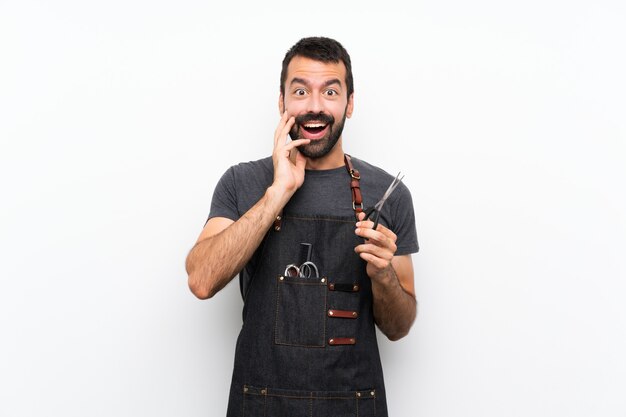 Barber man in an apron with surprise and shocked facial expression