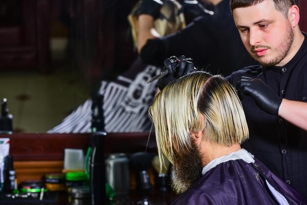 Foto barbiere professionista maestro che fa nuova acconciatura uomo ottiene taglio di capelli alla moda pettinatura alla moda per veri uomini bellezza e moda tingere i capelli e dare nuova forma al parrucchiere maschile