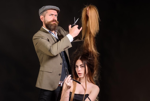 Barber scissors Hairdresser makes hairstyle a woman with long hair Master hairdresser does hairstyle and style with scissors Professional hairstylist