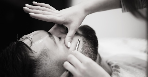 Barber shaves the bearded man