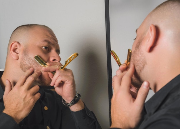 Barber shaving himself in front of the mirror