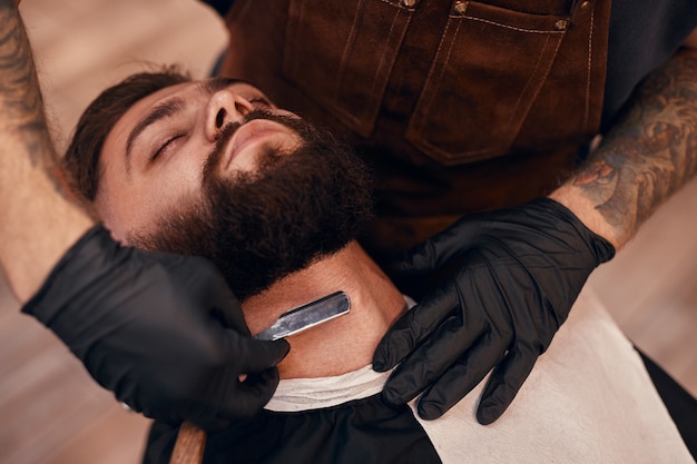 Photo barber shaving neck of a customer