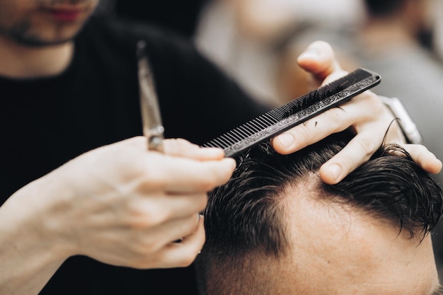 Barbiere tosatura della barba all'uomo nel negozio di barbiere che incornicia l'attaccatura dei capelli rasoio elettrico vintage tinto di marrone