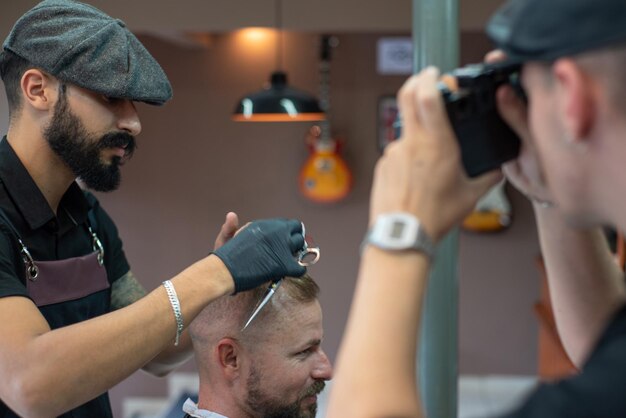 Barber shop barber shaving his client selective focus