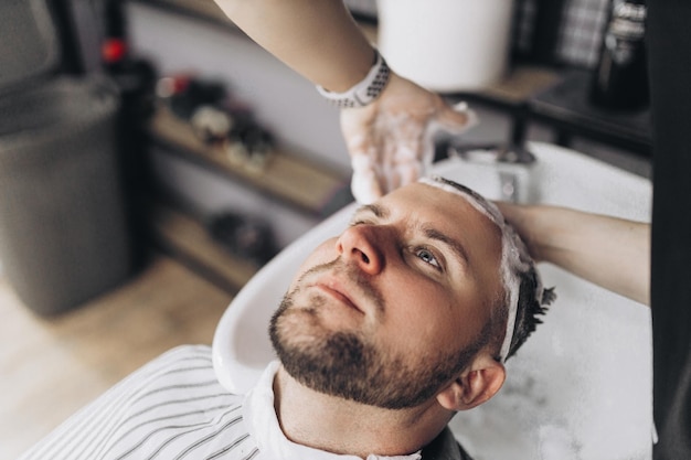 Barber shop Hairdresser man washes client head in barbershop High quality photography