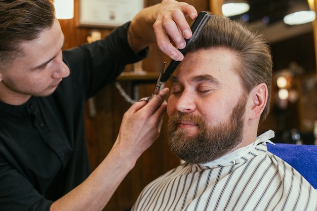 理髪店、ひげを生やした美容師。美しい髪とケア、男性用ヘアサロン