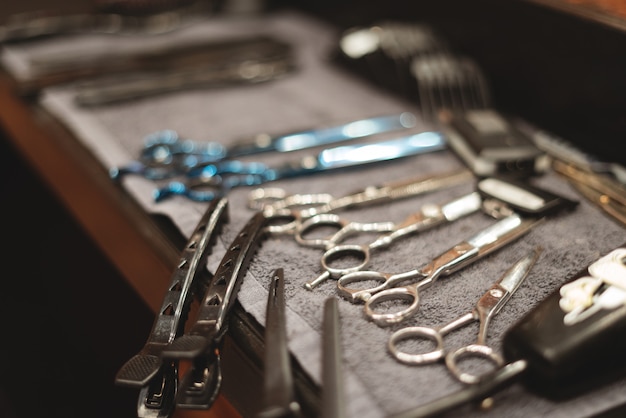 Barber tool in barbershop. Hairdresser tool. Scissors, combs, razors, clippers. Tool for the wizard. Organization of workplace.