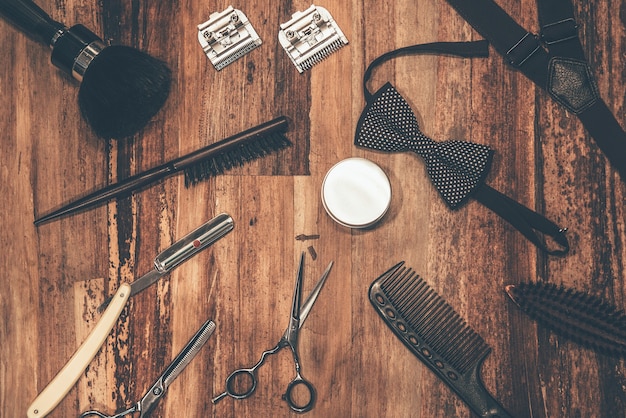 Foto strumenti del barbiere. vista dall'alto di strumenti da barbiere e accessori da uomo sdraiati sulla venatura del legno