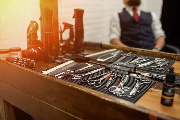 Barber tools on wooden shelf and mirror in barbershop