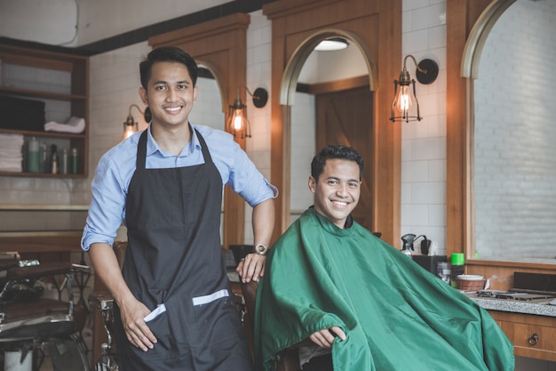 Barber with client sitting on a chair ready to get his hair cut