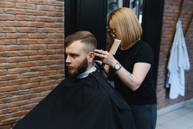 Barber Woman Cutting Man Hair at the Barbershop.