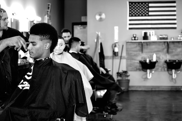 Foto barbers die klanten haar snijden in de salon.