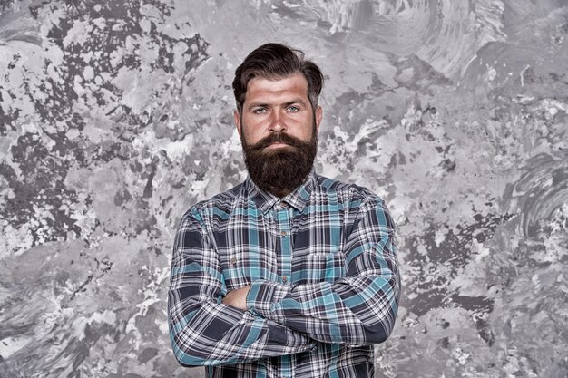 Barbershop grooming Stylish man grunge background Handsome man wearing checkered shirt mature hipster perfect moustache hairdresser and barbershop hair and beard care portrait of masculinity