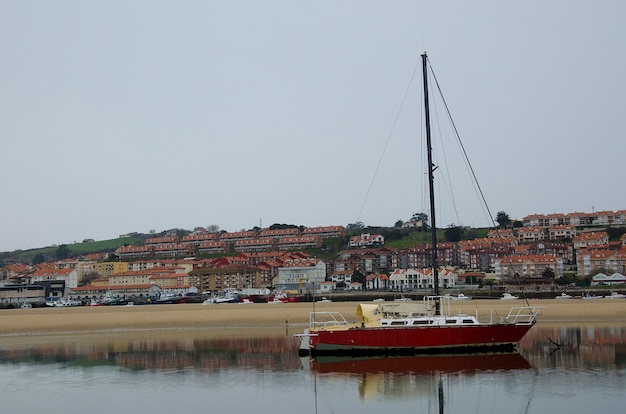 Photo barco en la mar junto a casas con reflejo