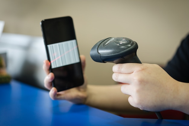 A barcode scanner scanning a barcode on a mobile/cellular phone screen