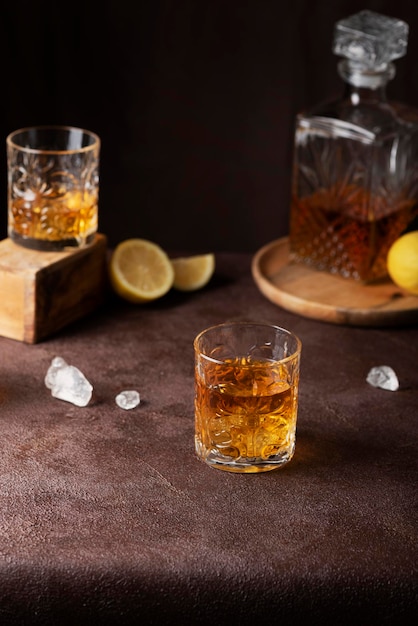 Barconcept: glazen rum met ijs en citroen op de bruine achtergrond, selectieve focusafbeelding