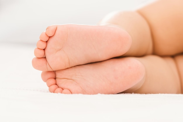 Bare feet of a baby sleeping on a white blanket