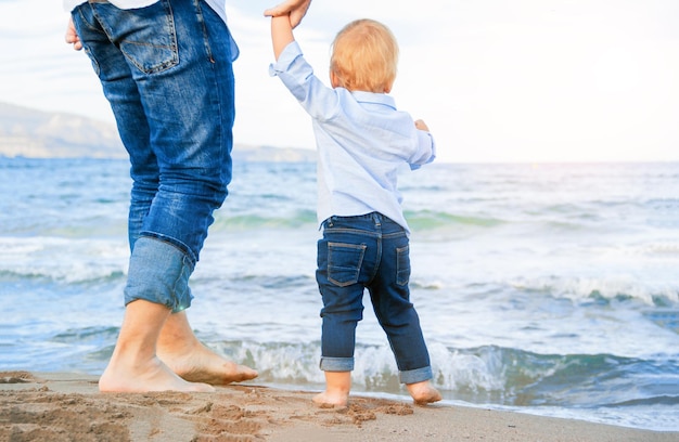 Bare feet of child and adult on the sea vacation concept Happy