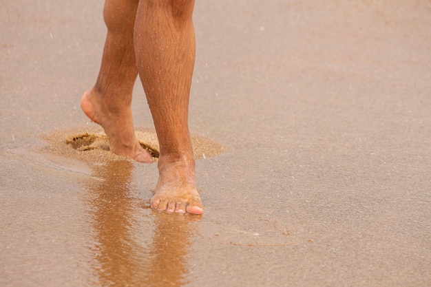 Photo bare feet walking on the beach sand