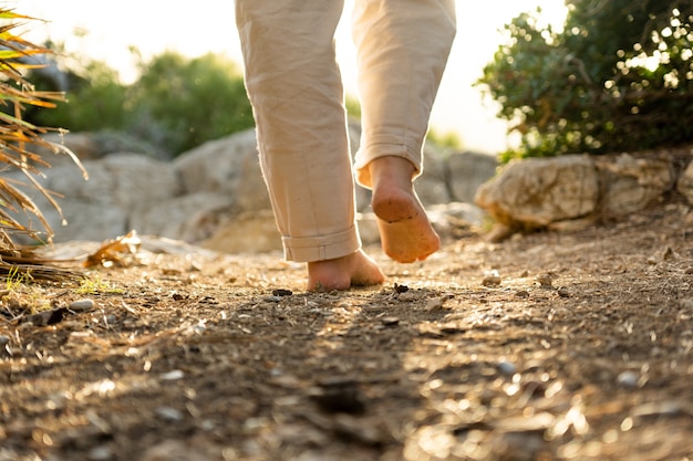 Piedi nudi che camminano sulla terra con una splendida luce del tramonto