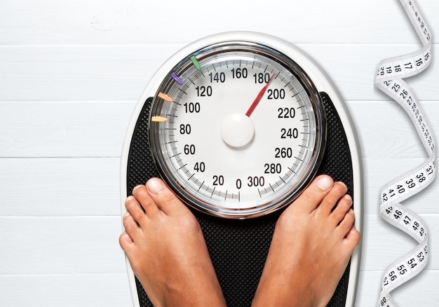 Bare female feet standing on bathroom scale