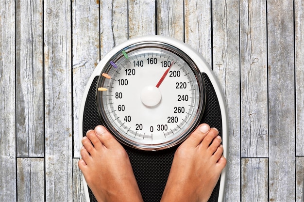 Bare female feet standing on bathroom scale