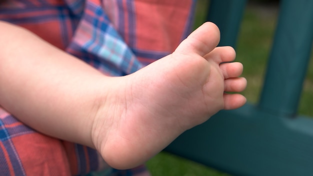 Bare foot of newborn baby. Tiny foot of infant girl or boy. Softness of newborns skin. Child care concept.