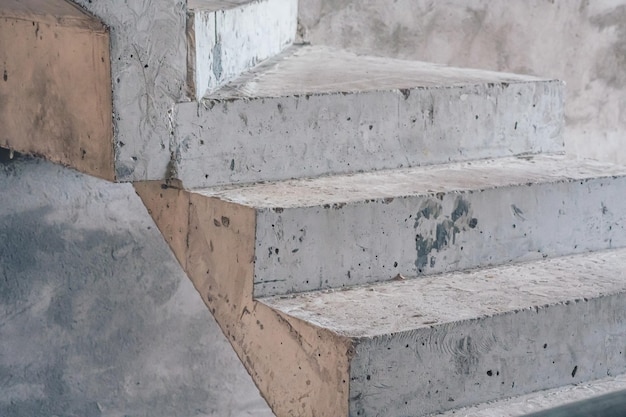 Bare grey cement concrete stairs leading up construction site\
unfinished staircase architecture copy space closeup abstract\
background city inside building geometry visible texture\
industrial