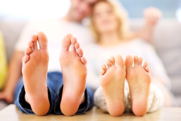 Photo barefeet couple lying on a sofa