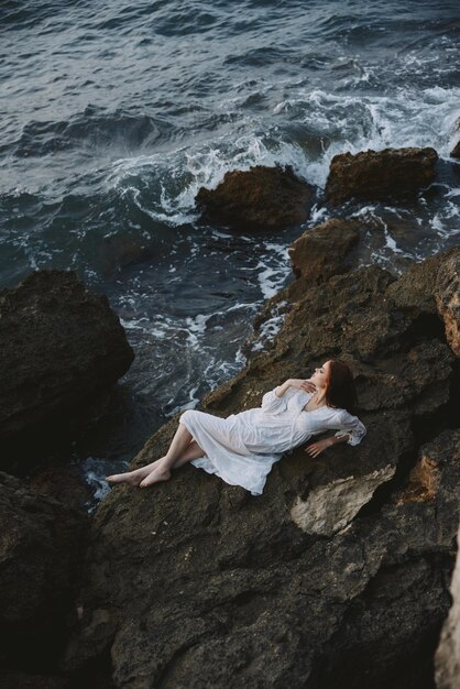 Barefoot vrouw in witte trouwjurk op kust nat haar natuur landschap