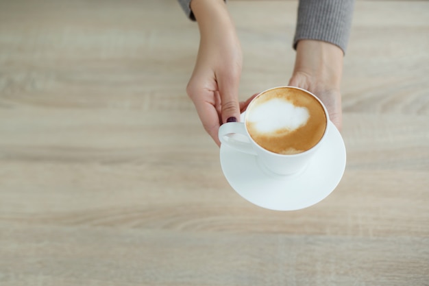 Barista in apron in coffee shop give just brewed fresh coffee to customer