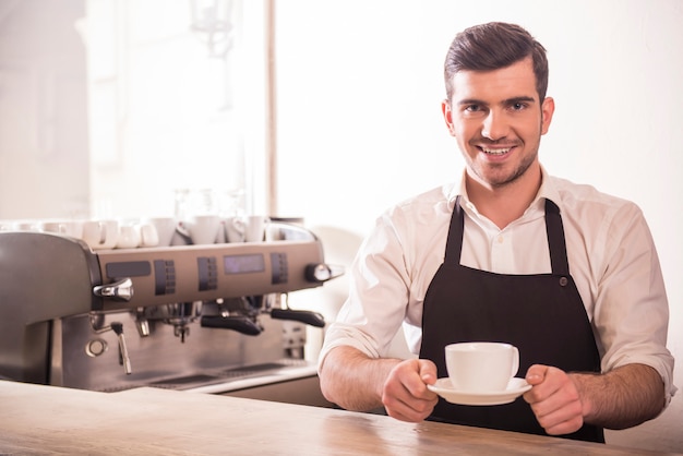 Barista bereidt cappuccino in zijn koffieshop.