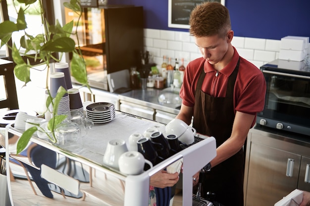 Barista bereidt koffie op professionele stoomkoffiemachine achter een toog in een prachtig café